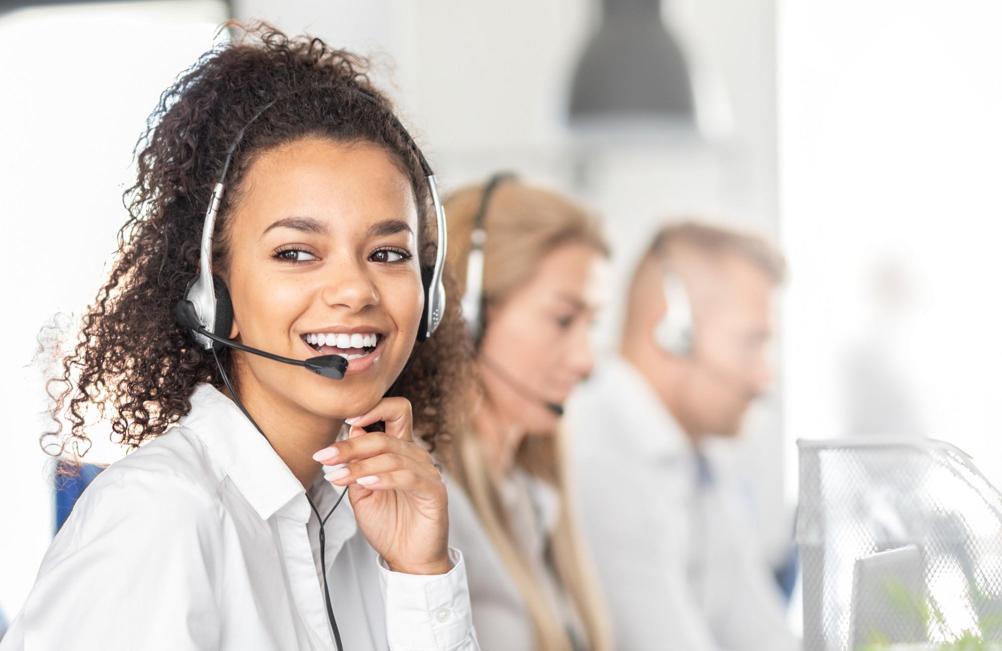 Smiling woman wearing a headset ready to take your customer service call.